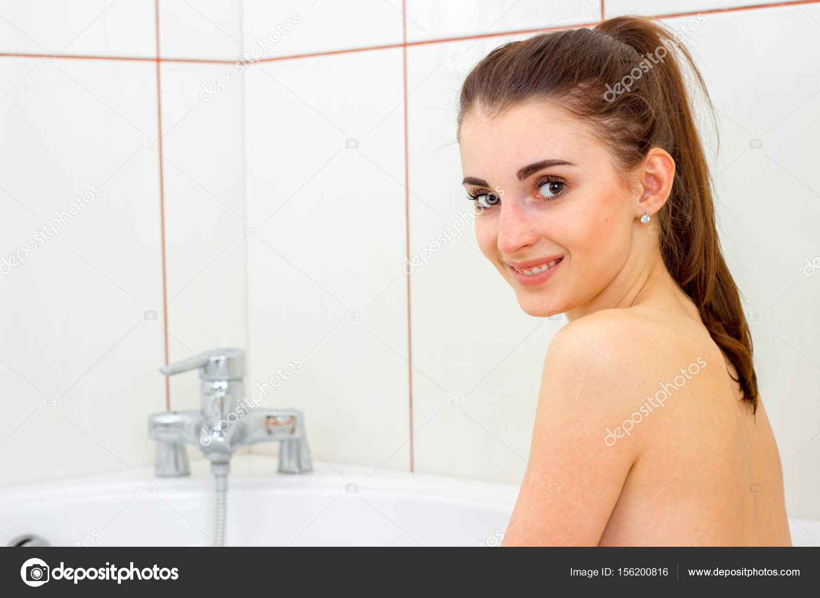 Cute young girl bathed in the bathtub and smiles at the camera — Stock ...
