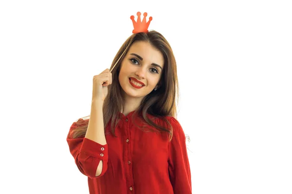 A beautiful young woman in a red shirt smiling at the camera with a paper Crown on head — Stock Photo, Image