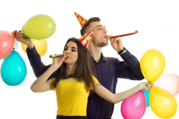 Casal feliz na festa de aniversário com chifres e balões — Fotografia de Stock