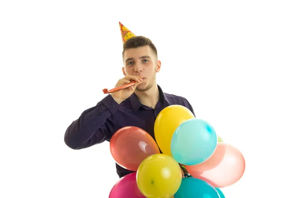 Glad ung man blåsa horn på födelsedagsfest — Stockfoto
