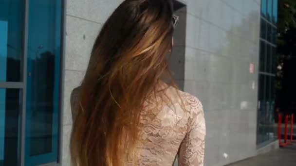 Menina com óculos brilhantes sorrindo gira em torno de si mesma e seu cabelo voar pelo ar — Vídeo de Stock