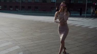 muhteşem genç iş kadını yürür ve konuşan telefon