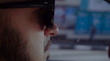 güneş gözlüklü genç adam bir araba bir yolda