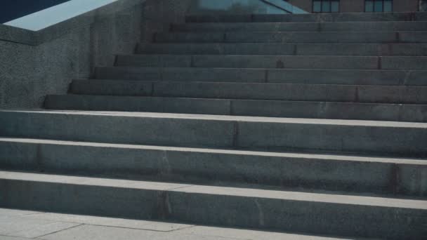 Fiatal üzletember ruha megy le a lépcsőn, az utcán — Stock videók