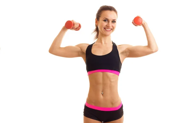 Fun energetic athlete raised the dumbbells in your hands looks into the camera and laughs — Stock Photo, Image
