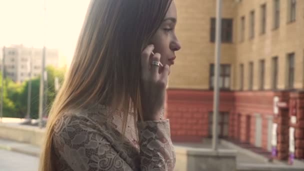 Mooi blond meisje gesprekken op mobiele telefoon buitenshuis — Stockvideo