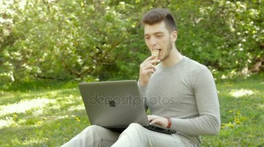 Dondurma ve laptop parkta taping neşeli genç öğrenci yiyor