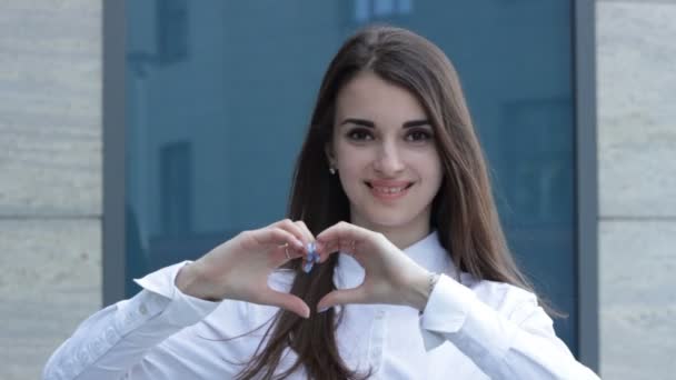 ビジネスの女性は、心の手シンボルを示していますと笑顔 — ストック動画