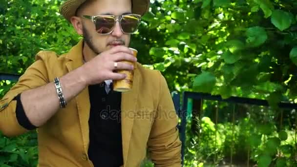 Jovem elegante no parque beber café — Vídeo de Stock