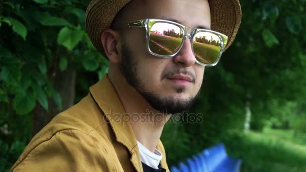 Bello giovane uomo in occhiali da sole specchio dorato sorridente sulla macchina fotografica — Video Stock