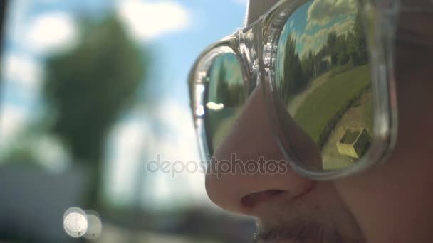 Tükröződik a srác a szemüveget utcai fák — Stock videók