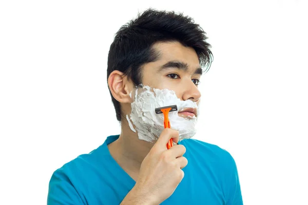 Ritratto di un bel ragazzo che ti ha causato la schiuma sul viso e si rasa la barba — Foto Stock