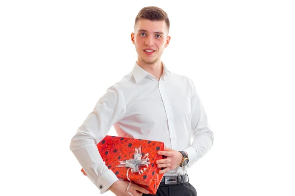 Eleganter Kerl in weißem Hemd und einem großen roten Geschenk in den Händen — Stockfoto