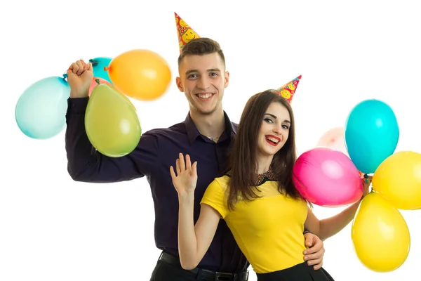 Vrolijke jonge paar met ballonnen in hun handen glimlachen — Stockfoto