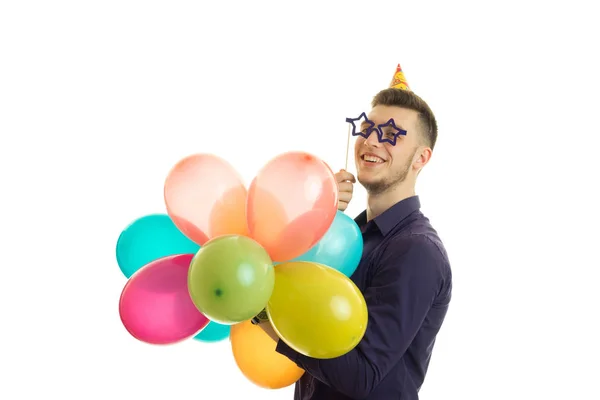 Joven feliz en vasos de papel y globos en sus manos sonriendo — Foto de Stock