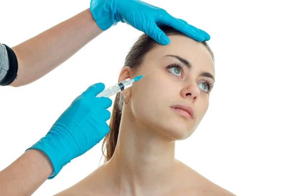 Médico en guantes azules cabeza inclinada chica joven y hace sus inyecciones —  Fotos de Stock