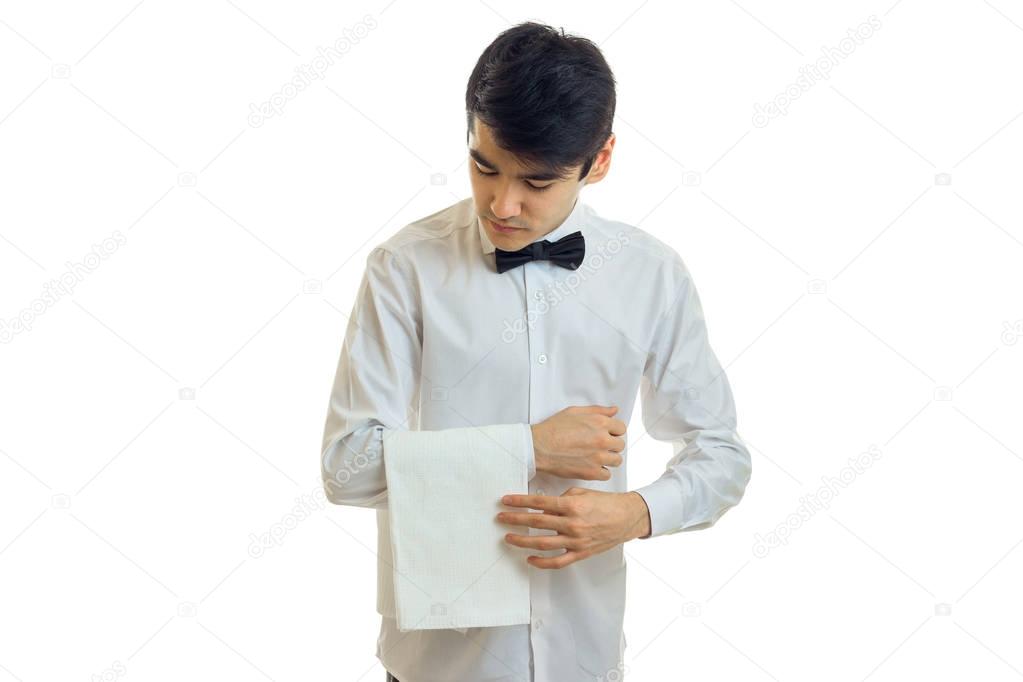 a young waiters shirt carefully hangs towel on hand