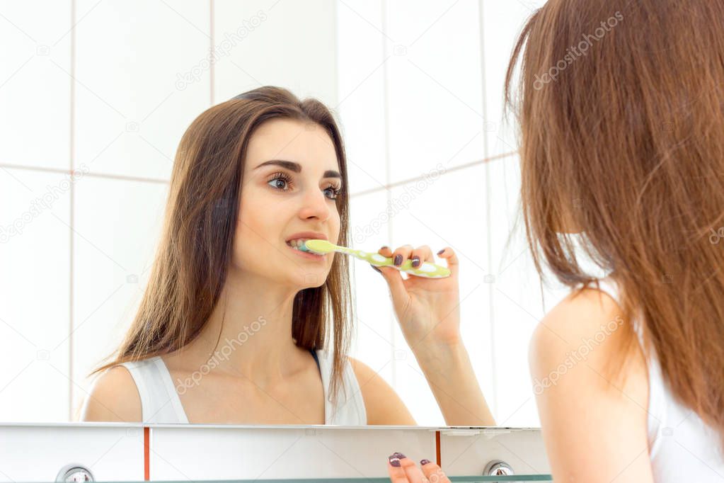 woman brushing teeth with a brush before bedtime