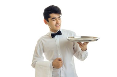 Genç sevimli garson için yeme ve gülümseyen onun eli boş tepsi kaldırdı