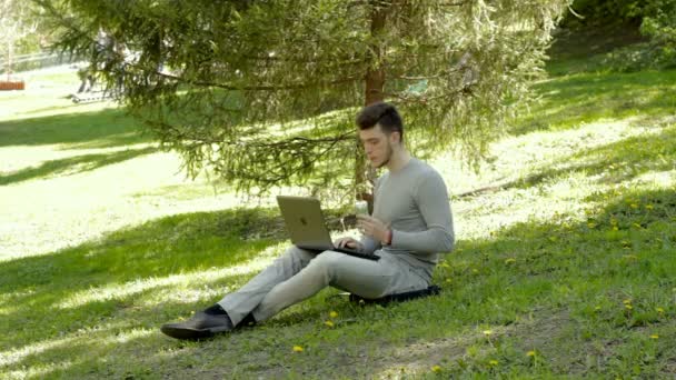 Student works with laptop and eats ice cream in a warm day — Stock Video