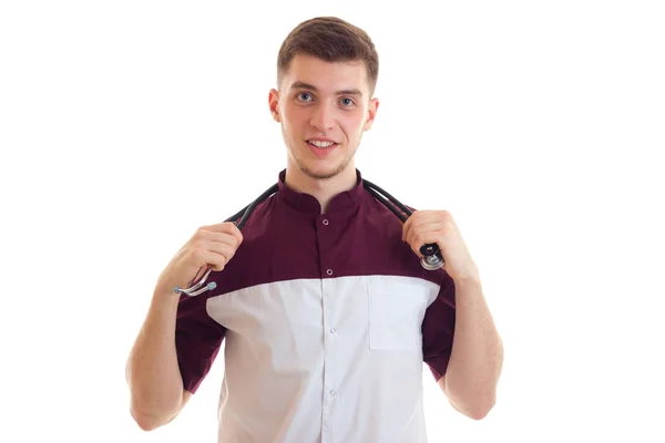Веселий молодий лікар в уніформі зі стетоскопом посміхається — стокове фото