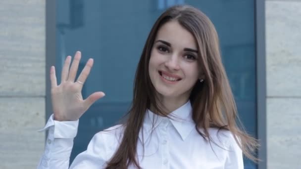 Очаровательная девушка улыбается в камеру и показывает жест пять — стоковое видео