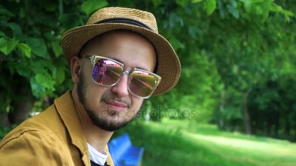 帽子とサングラスのカメラに笑顔で陽気な若い男 — ストック動画