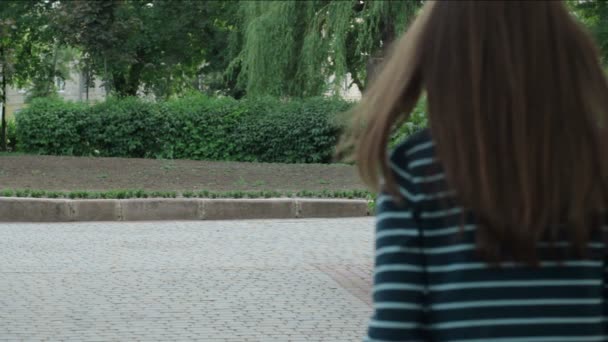 Ein Mann mit einem Mädchen, das Händchen haltend im Park geht — Stockvideo