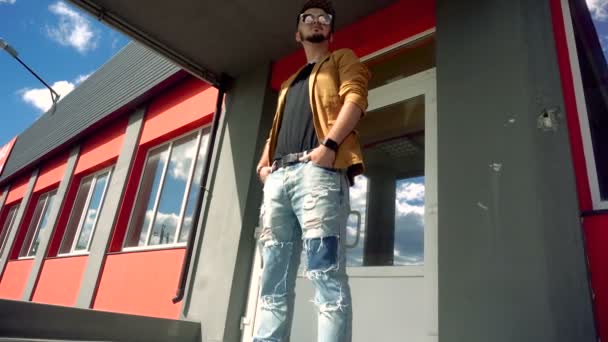 Молодой человек стоит на улице и улыбается — стоковое видео