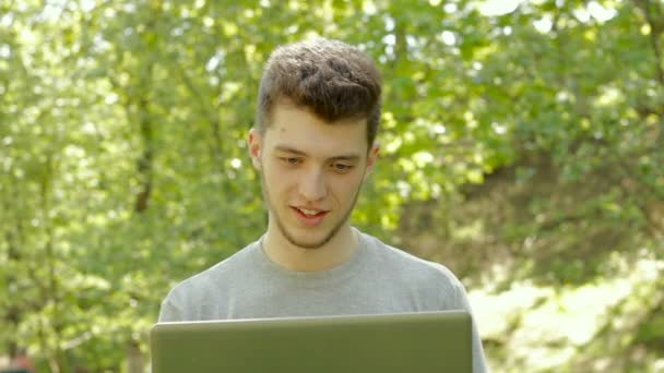 Young guy working with laptop and laughing — Stock Video