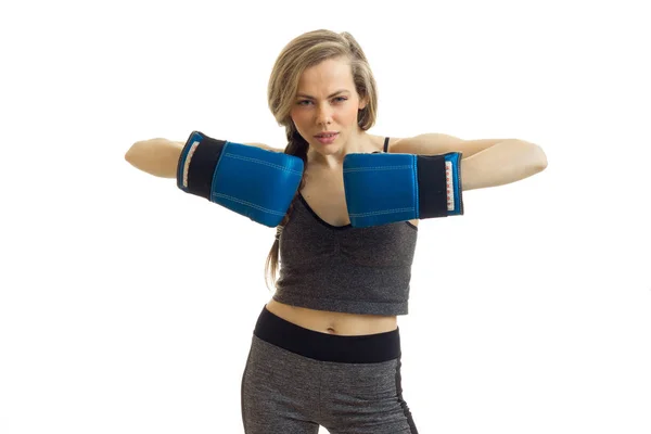 Bella ragazza sportiva bionda in uniforme e guanti da boxe blu guardando la fotocamera — Foto Stock