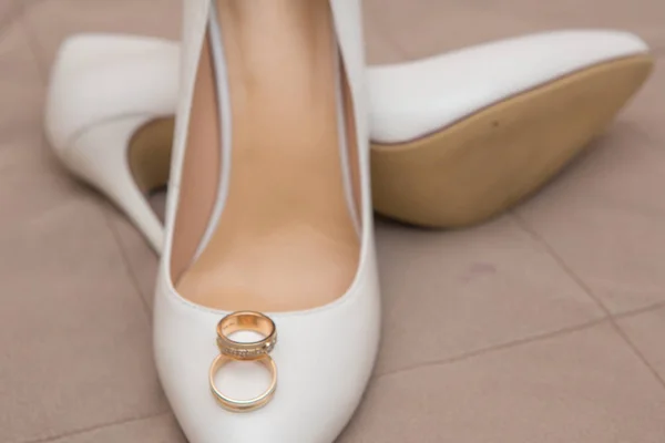 Gold wedding rings are on shoes — Stock Photo, Image