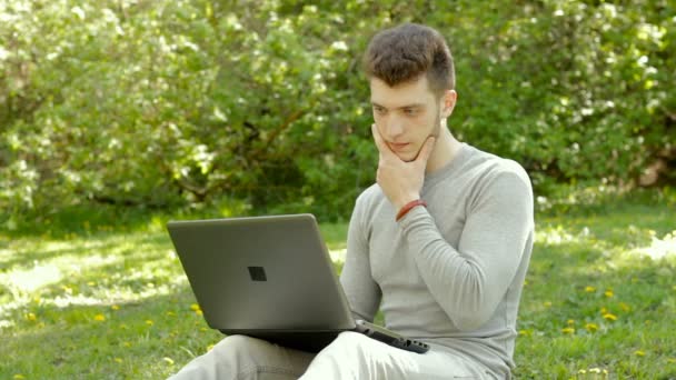 Hombre sorprendido freelancer trabajando con el ordenador portátil al aire libre — Vídeos de Stock