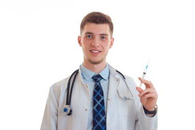 holding bir şırınga ve gülümsüyor üniformalı yakışıklı doktor