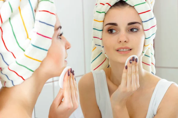Женщина стирает макияж с лица — стоковое фото