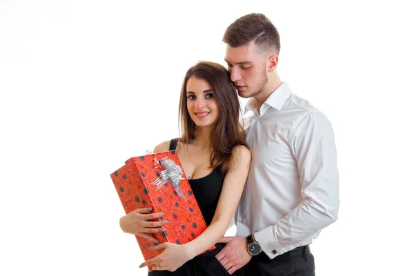 Cara abraça uma menina bonita e dar-lhe uma grande caixa de presente vermelho — Fotografia de Stock