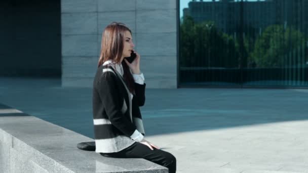 Φοιτητής όμορφο κορίτσι μιλάει στο κινητό τηλέφωνο σε εξωτερικούς χώρους — Αρχείο Βίντεο
