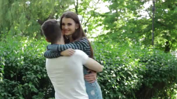 Homme tourne une fille sur les mains dans le parc — Video