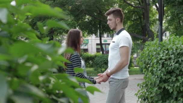 Пара в отношениях, держась за руки и разговаривая в парке — стоковое видео