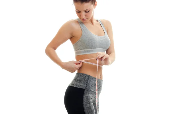 Athletic slender girl in top waist measures Ribbon — Stock Photo, Image