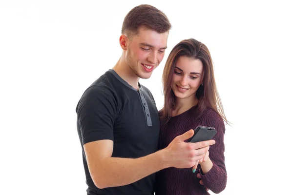 Красива любляча пара дивиться фотографію на вашому телефоні і посміхається ізольовано на білому тлі — стокове фото