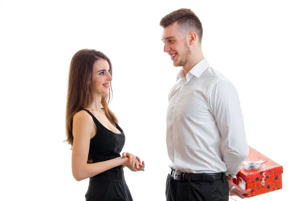 Beautiful smiling girl looks at the guy who brought her a gift and keeps behind — Stock Photo, Image