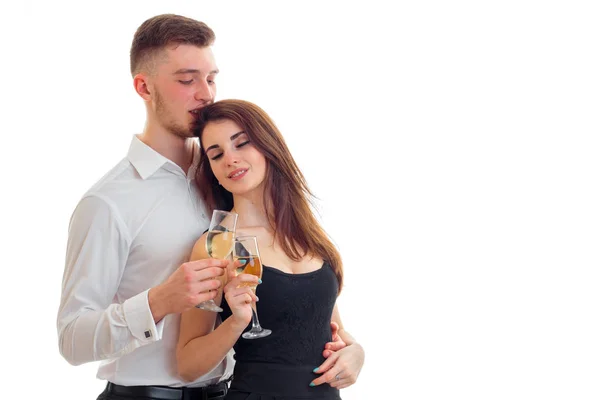 Schöne liebevolle Kerl und Mädchen mit Gläsern Wein posieren im Studio — Stockfoto