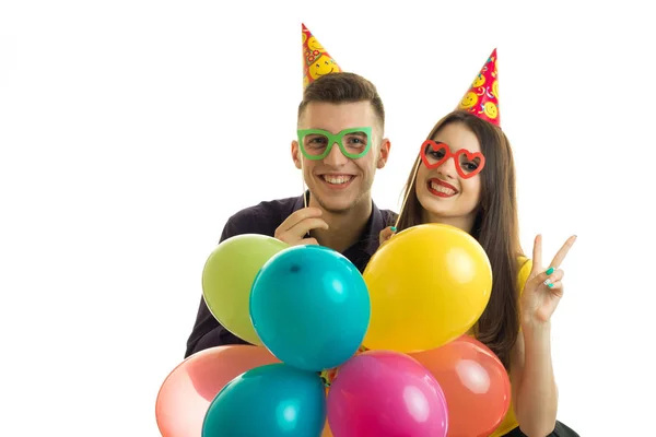 Porträtt av en vacker ung lyckliga par i glasögon och ballonger i händerna — Stockfoto