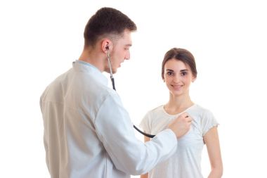 Doktor kalbi steteskop ile beyaz bir arka plan üzerinde izole bir genç kızdan dinler
