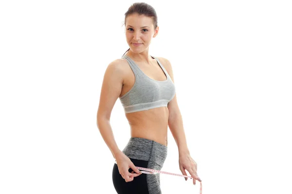 A young girl in an athletic form of smiles and takes the waist — Stock Photo, Image