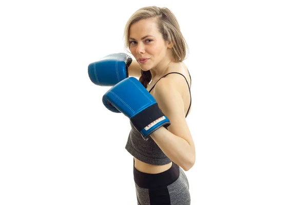 Hermosa rubia fuerte posando delante de la cámara en guantes de boxeo se aísla sobre un fondo blanco — Foto de Stock