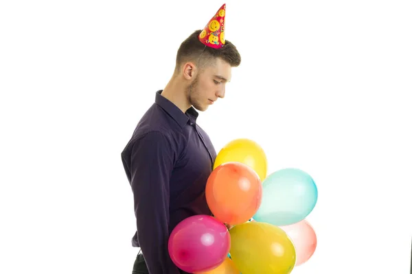 Chico joven se para en el estudio y tiene un montón de globos — Foto de Stock