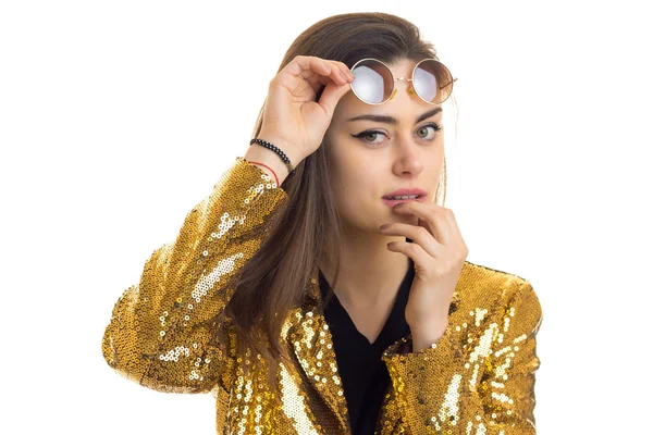 Jonge brunette vrouw in gouden jas kijken naar de camera — Stockfoto