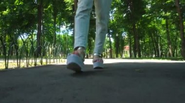 çizgili yüksek topuklar üzerinde kız parkta yürüyor